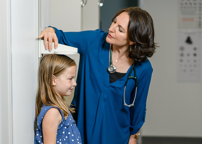 AIM Health physician measuring height of child in Oregon